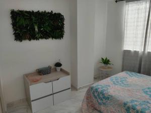 a bedroom with a bed and plants on the wall at Hermoso e iluminado apartamento. in Itagüí