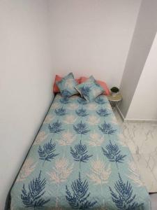 a bedroom with a bed with a blue blanket and pillows at Hermoso e iluminado apartamento. in Itagüí