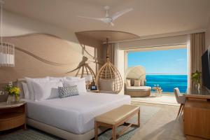 a bedroom with a bed and a view of the ocean at Breathless Cancun Soul Resort & Spa - Adults Only - All Inclusive in Cancún