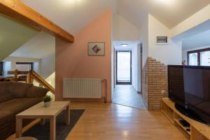 a living room with a couch and a tv at Apartma Ivano in Bohinj