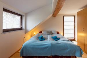 1 dormitorio con 1 cama azul y 2 almohadas azules en Apartma Ivano, en Bohinj