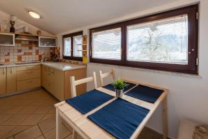 una cocina con una mesa de madera y una toalla azul. en Apartma Ivano, en Bohinj