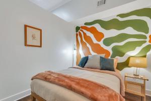 um quarto com uma cama com um quadro na parede em Broughton Bliss Loft- City Market Plant Riverside em Savannah