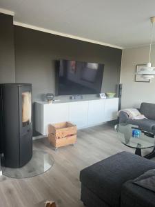uma sala de estar com um sofá e uma televisão de ecrã plano em Buvika Panorama 