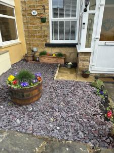 a house with a garden with flowers in a yard at Quaint 1 bedroom cottage in Pudsey, Leeds in Pudsey