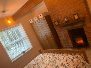 a bedroom with a fireplace and a bed and a window at Quaint 1 bedroom cottage in Pudsey, Leeds in Pudsey