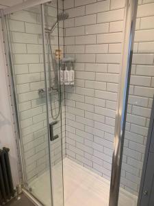 a shower with a glass door in a bathroom at Quaint 1 bedroom cottage in Pudsey, Leeds in Pudsey