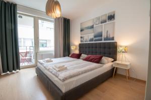 - une chambre avec un grand lit et une grande fenêtre dans l'établissement Krakovska CR Apartments, à Prague