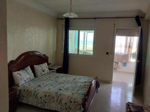 Schlafzimmer mit einem Bett und einem Fenster in der Unterkunft Piso vistas al mar in Asilah
