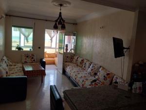 ein Wohnzimmer mit einem Sofa und einem TV in der Unterkunft Piso vistas al mar in Asilah