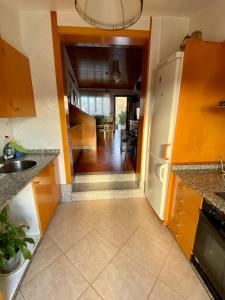 a kitchen with a sink and a refrigerator at Casa Rural Albores Grande Nigrán in Nigrán