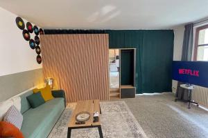 un salon avec un canapé et une table dans l'établissement Modern City Apartment l Netflix l fast wifi l Xbox, à Berlin