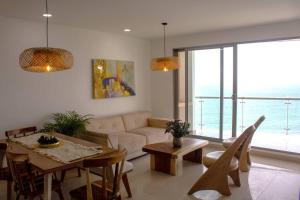 sala de estar con sofá, mesa y sillas en NUEVO! Hermoso apto frente a la playa!, en Cartagena de Indias