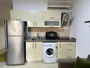 een keuken met een koelkast en een wasmachine bij Homie 1- master bedroom, pool and garden view in Sharm el Sheikh in Sharm El Sheikh