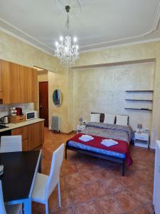 a bedroom with a bed and a kitchen with a chandelier at Bardonecchia Central Studio Apartment - Frejus Palace in Bardonecchia
