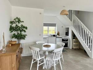 a kitchen with a table and chairs and a staircase at Muckish Maison in Dunfanaghy