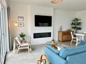 a living room with a blue couch and a fireplace at Muckish Maison in Dunfanaghy