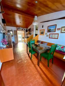 a living room with a table and green chairs at Casa Rural Albores Grande Nigrán in Nigrán