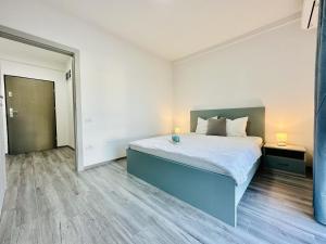 1 dormitorio con 1 cama grande y pasillo en Bleu Apartment Baile Felix, en Băile Felix