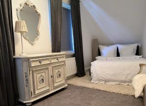 a bedroom with a bed and a dresser with a mirror at Ferienwohnung und Appartement nähe Möhnesee für 4 Personen in Warstein