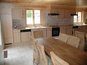 a kitchen with a wooden dining table and chairs at Holiday home with a panoramic view of the Ourthe on a quietly located property in La Roche-en-Ardenne