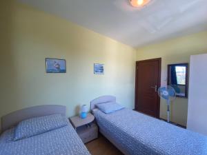 um quarto com 2 camas, uma ventoinha e uma porta em AMADEUS 1 - 13B Large Two Bedroom Apartment em Sunny Beach