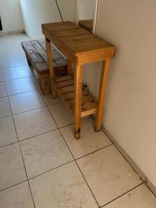 a wooden table sitting on a floor next to a wall at Hotel Regina “El Llano” in Cosalá