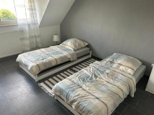 2 aparte bedden in een slaapkamer met een raam bij Schöner Wohnen in Bünde in Bünde