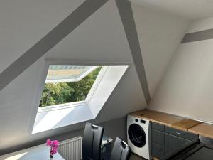 an attic room with a window and a washing machine at Schöner Wohnen in Bünde in Bünde