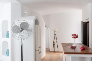 a kitchen with a refrigerator and a table with a fan at Ode Villa in Oia