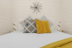 a white bed with pillows and a snowflake on the wall at New The Yellow Beacon-Luxury Shipping Container in Fredericksburg