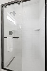 a shower with a glass door in a bathroom at New The Yellow Beacon-Luxury Shipping Container in Fredericksburg