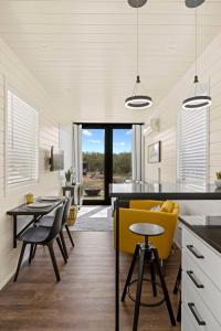 a kitchen and dining room with a yellow chair at New The Yellow Beacon-Luxury Shipping Container in Fredericksburg