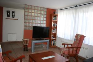 sala de estar con TV, mesa y sillas en Vivienda Turistica Rural Piskerra, en Carcastillo