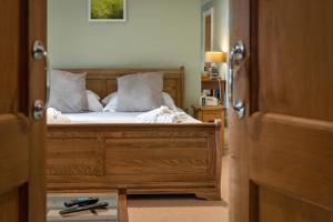 a bedroom with a bed with white sheets and pillows at Slebech Park Estate in Wiston