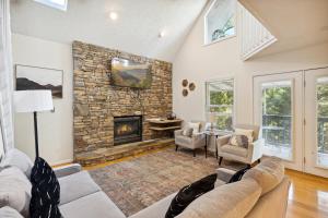 a living room with a couch and a stone fireplace at Valley Heights home in Pigeon Forge