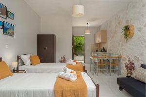 ein Hotelzimmer mit 2 Betten und einer Küche in der Unterkunft Barbara Ann Apartments in Alikanas