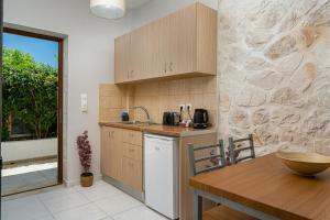 eine Küche mit einem Tisch, einer Spüle und einer Theke in der Unterkunft Barbara Ann Apartments in Alikanas
