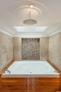 a large bath tub in a bathroom with a chandelier at Slebech Park Estate in Wiston