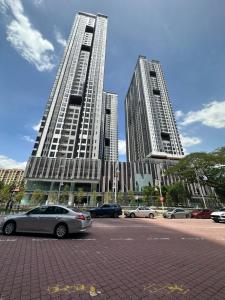 two tall buildings with cars parked in a parking lot at Sentral Suites KualaLumpur in Kuala Lumpur