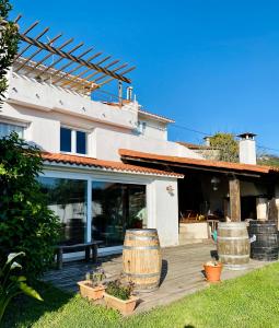 Casa con terraza de madera con 2 barriles grandes en Casa Rural Albores Grande Nigrán, en Nigrán