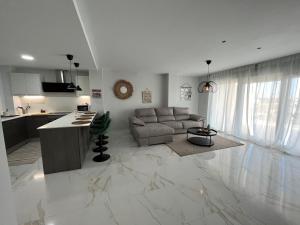 Una cocina y una sala de estar con un sofá y una mesa. en TERRAZA LA MARINA, en Elche