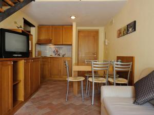 cocina y sala de estar con mesa y sillas en Elegant apartment in resort with swimming pool featuring nature and tranquillity, en Foligno