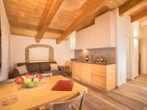 una cocina y una mesa con un bol de fruta. en Elegant apartment in resort with swimming pool featuring nature and tranquillity, en Foligno