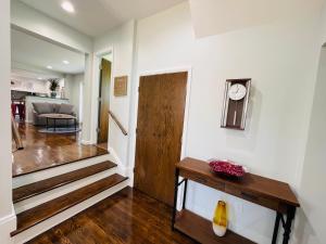 a living room with a staircase and a clock on a wall at Sonsak - Unit 1 in Charlottesville
