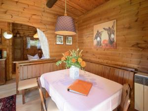 un comedor con una mesa en una cabaña en Cozy holiday home on a horse farm in the L neburg Heath, en Eschede