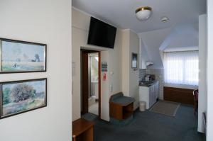 a room with a bathroom with a sink and a kitchen at Alfa Apartment Hotel in Neu Isenburg