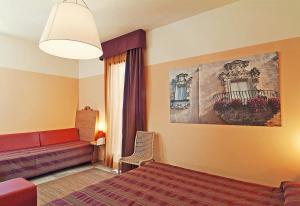 ガリアーノ・デル・カーポにあるIl Tabacchificio Hotelのベッドルーム1室(ベッド1台、ソファ、窓付)