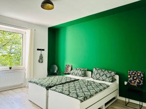 a green bedroom with a bed and a green wall at FeWo Ischeland near Hagen-City in Hagen