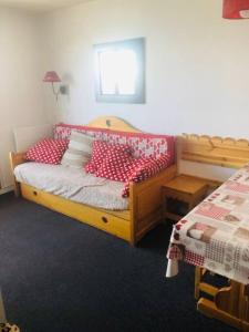 1 dormitorio con 1 cama con almohadas rojas y blancas en Appartement risoul 1850 residence pegase en Risoul